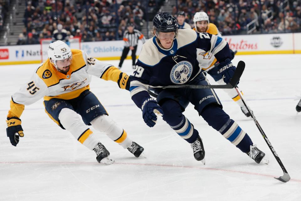 Columbus Blue Jackets' Patrik Laine, right, carries the puck up ice as Nashville Predators' Alexandre Carrier defends during the second period of an NHL hockey game Thursday, Dec. 30, 2021, in Columbus, Ohio. (AP Photo/Jay LaPrete)