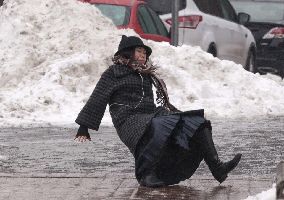 A woman falls while slipping on ice during freezing rain on Roosevelt Island, a borough of Manhattan in New York