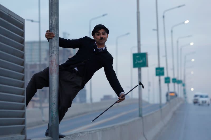 Usman Khan, 29, dressed up as Charlie Chaplin, performs along the street in Peshawar