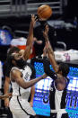 Brooklyn Nets guard James Harden, left, shoots as Los Angeles Clippers guard Paul George defends during the first half of an NBA basketball game Sunday, Feb. 21, 2021, in Los Angeles. (AP Photo/Mark J. Terrill)