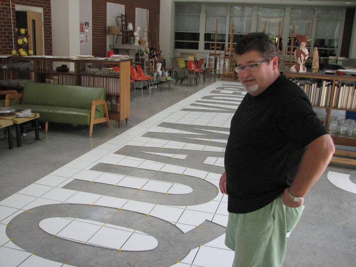 Will Hinton examines his 80 x 20 foot mosaic mural displaying the state motto, “Esse Quam Videri,” while it was in progress. It means “To be, rather than to seem” and covers a wall in downtown Louisburg.