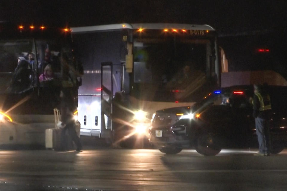 Migrants board buses as they arrived on a plane from San Antonio at Chicago Rockford International Airport at 1am on Jan. 1, 2024 in Rockford, Ill. The city of Chicago said 355 migrants on the Boeing 777 boarded eight buses chartered by Abbott to be dropped off in "various suburbs." (WTVO NewsNation via AP)