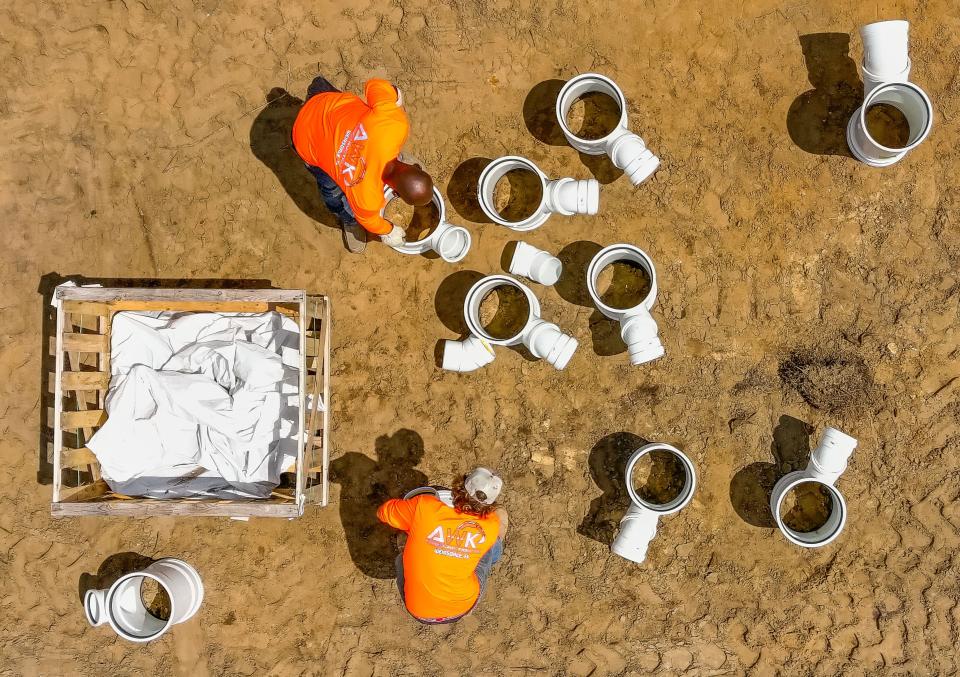 AWK Construction employees put together pipe fittings while preparing to install a water and sewer main in early April.