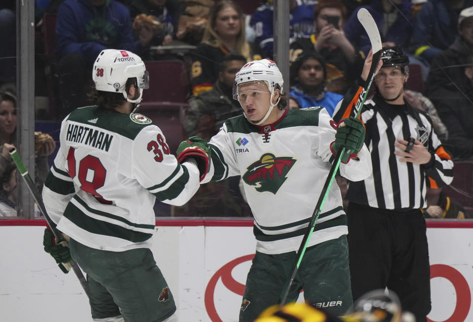 Minnesota Wild's Kirill Kaprizov (97) celebrates his second goal against the Vancouver Canucks with Ryan Hartman (38), during the second period of an NHL hockey game Thursday, March 2, 2023, in Vancouver, British Columbia. (Darryl Dyck/The Canadian Press via AP)