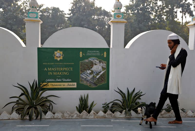 FILE PHOTO: A Muslim man walks his goat at a site that was allotted by authorities for a new mosque, about 15 miles from the Hindu Ram Temple, in Ayodhya