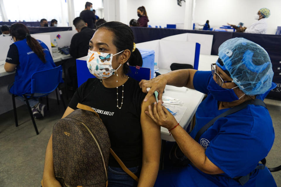 A health worker administering a COVID-19 vaccine booster shot on March 22, 2022, in San Salvador, El Salvador.<span class="copyright">Emerson Flores—APHOTOGRAFIA/Getty Images</span>