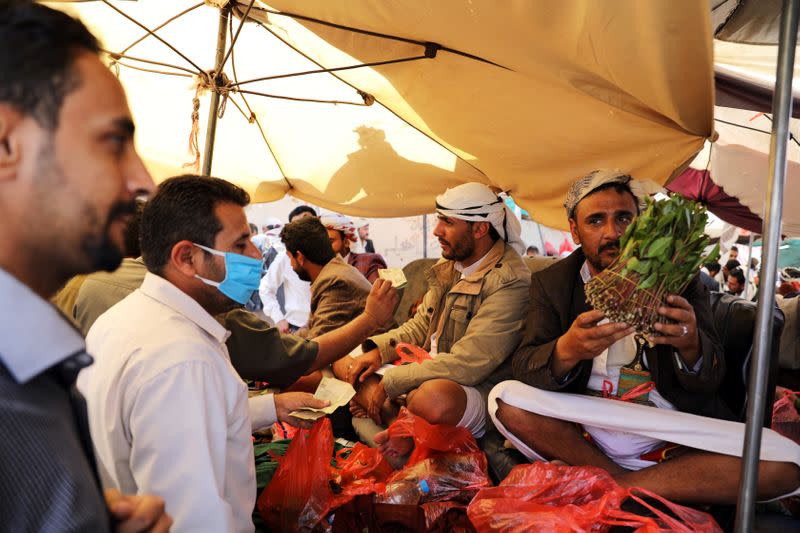 Vendor holds qat, a mild stimulant, at a qat market amid concerns of the spread of the coronavirus disease (COVID-19) in Sanaa