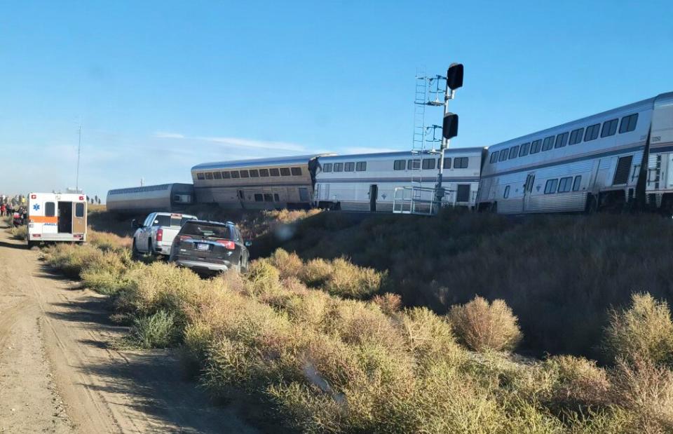 In this photo provided by Kimberly Fossen an ambulance is parked at the scene of an Amtrak train derailment on Saturday, Sept. 25, 2021, in north-central Montana. Multiple people were injured when the train that runs between Seattle and Chicago derailed Saturday, the train agency said.