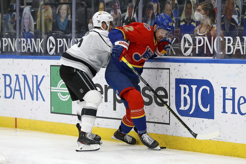 Los Angeles Kings' Matt Roy (3) and St. Louis Blues' Zach Sanford (12) vie for control of the puck during the second period of an NHL hockey game Monday, Feb. 22, 2021, in St. Louis. (AP Photo/Scott Kane)