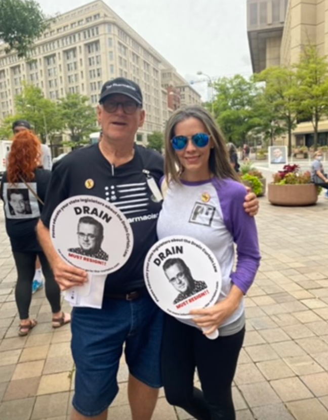 Dan Schneider, a pharmacist and activist, stands with Tonya Doucette at a protest. Doucette lost her son to fentanyl and has since worked to raise awareness and help people in recovery.