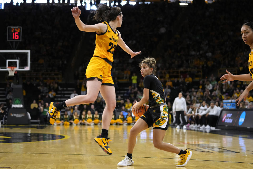 Southeastern Louisiana guard Cierria Cunningham, right, passes around Iowa guard Caitlin Clark (22) in the first half of a first-round college basketball game in the NCAA Tournament, Friday, March 17, 2023, in Iowa City, Iowa. (AP Photo/Charlie Neibergall)