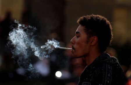 FILE PHOTO: A man smokes cannabis at a pro-cannabis rally beside the Houses of Parliament in London, April 20, 2015 REUTERS/Cathal McNaughton/File Photo