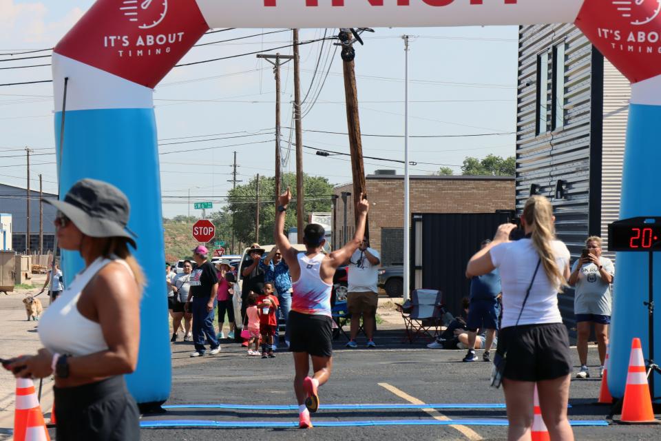 Ricardo Aguilar crosses the finish line first Saturday morning during the Fitness @ KT Black 5K/1K Run/Walk, which was part of the Texas Route 66 Festival and benefitting the Hope Lives Here organization.