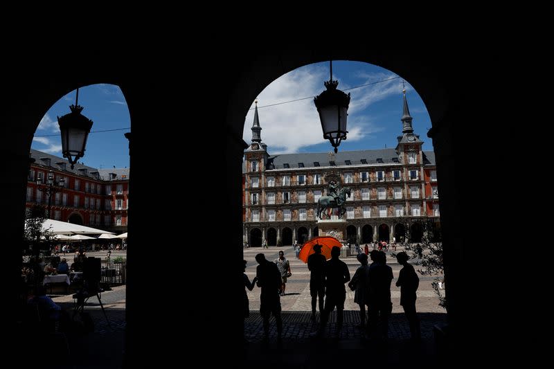 Tourists stand in the shade on a hot day as Spain braces for a heatwave in Madrid