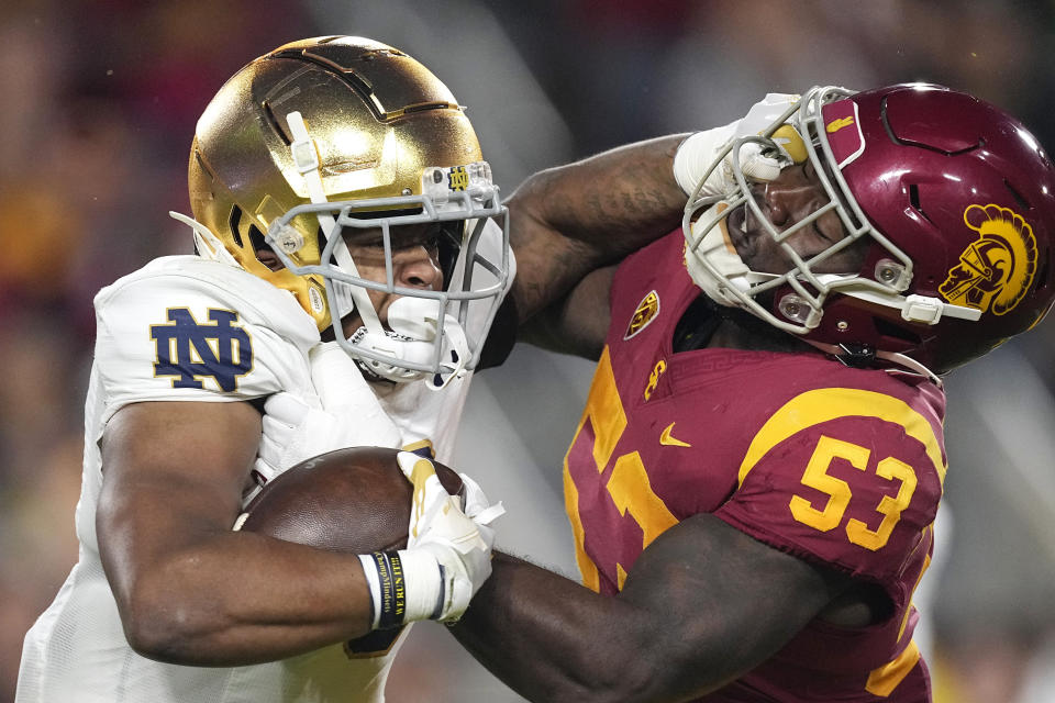 Notre Dame running back Logan Diggs, left, stiff-arms Southern California linebacker Shane Lee during the first half of an NCAA college football game Saturday, Nov. 26, 2022, in Los Angeles. (AP Photo/Mark J. Terrill)