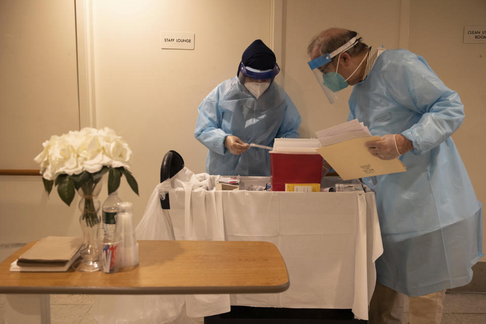 FILE - In this Jan. 15, 2021, file photo, CVS Pharmacists prepare the COVID-19 vaccine for the nursing home residents at Harlem Center for Nursing and Rehabilitation, a nursing home facility in Harlem neighborhood of New York. Nursing homes have to publicly disclose their vaccination rates for flu and pneumonia, but there’s no similar mandate for COVID-19 shots. (AP Photo/Yuki Iwamura, File)