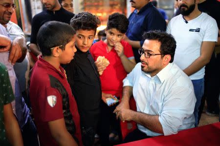 Muntazer al-Zaidi, a candidate on the Sairun list, speaks with boys in the Sadr City district of Baghdad, Iraq May 10, 2018. Picture taken May 10, 2018. REUTERS/Thaier al-Sudani