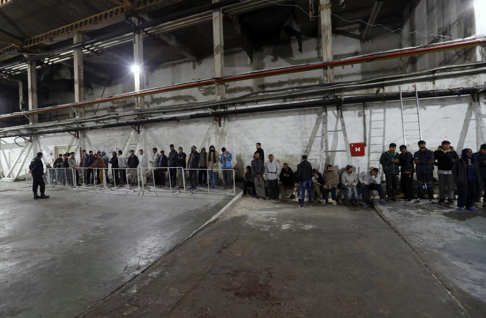 Migrants wait in line to receive food in the Bira refugee camp in Bihac, northwestern Bosnia, Thursday, Nov. 14, 2019. The European Union's top migration official is warning Bosnian authorities of a likely humanitarian crisis this winter due to appalling conditions in overcrowded migrant camps in the country. (AP Photo/Darko Vojinovic)