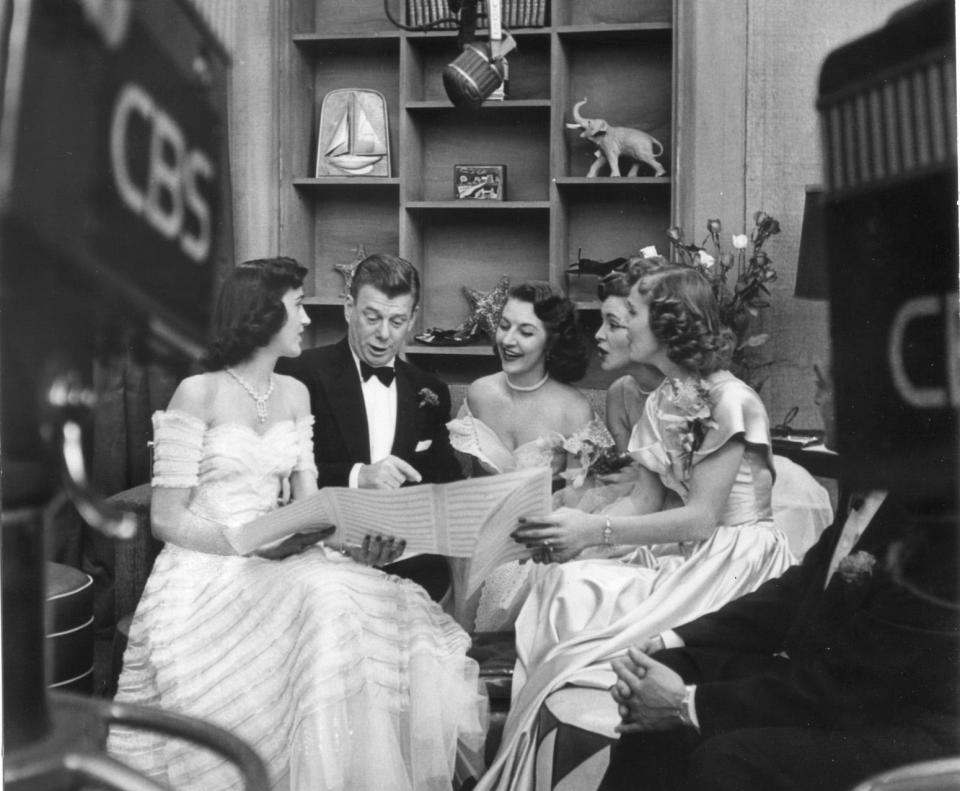 FILE - This is a handout photo of Authur Godfrey going over some sheet music with the Chordettes when they were at their apex of fame.