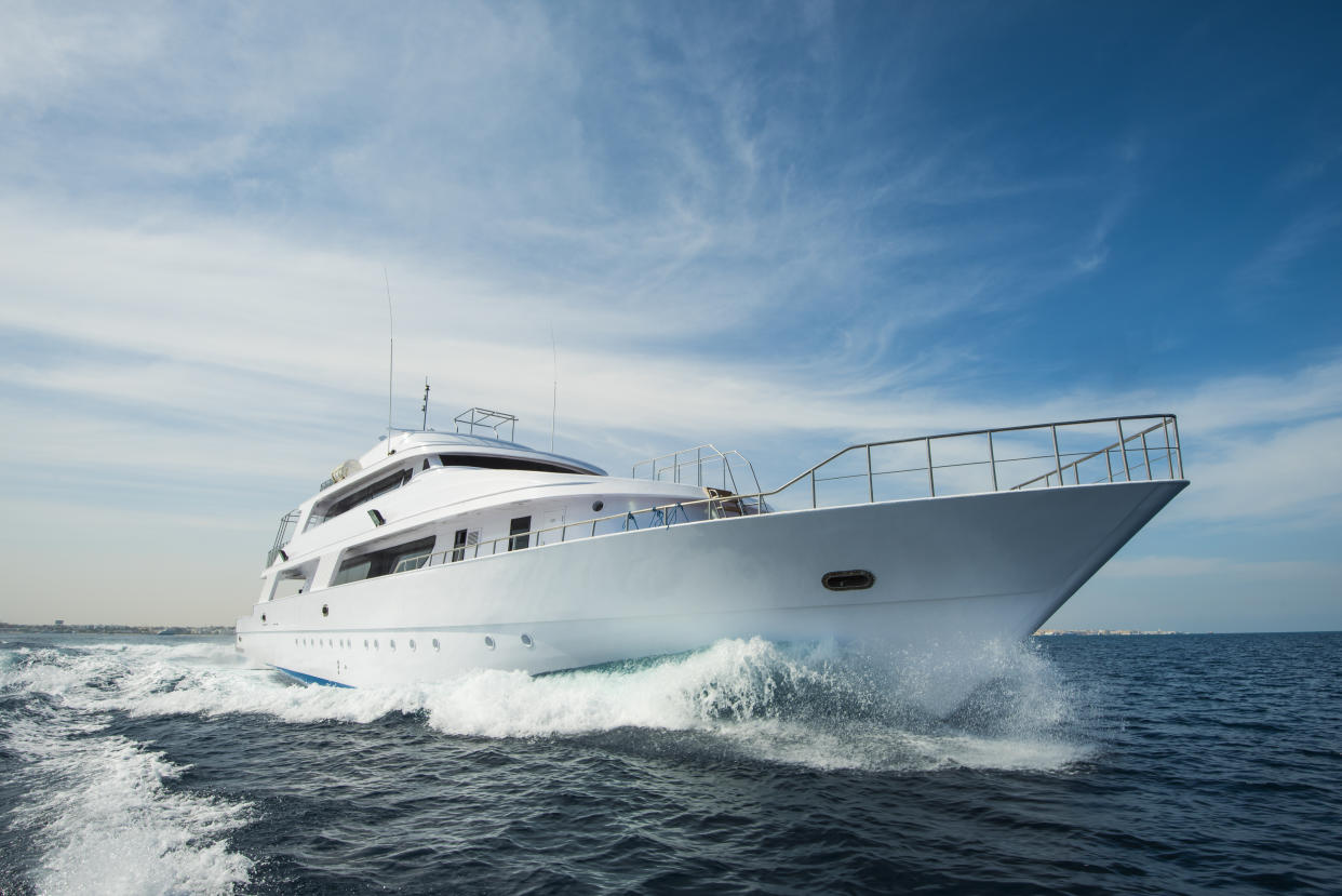 A luxury private motor yacht under way on tropical sea with bow wave