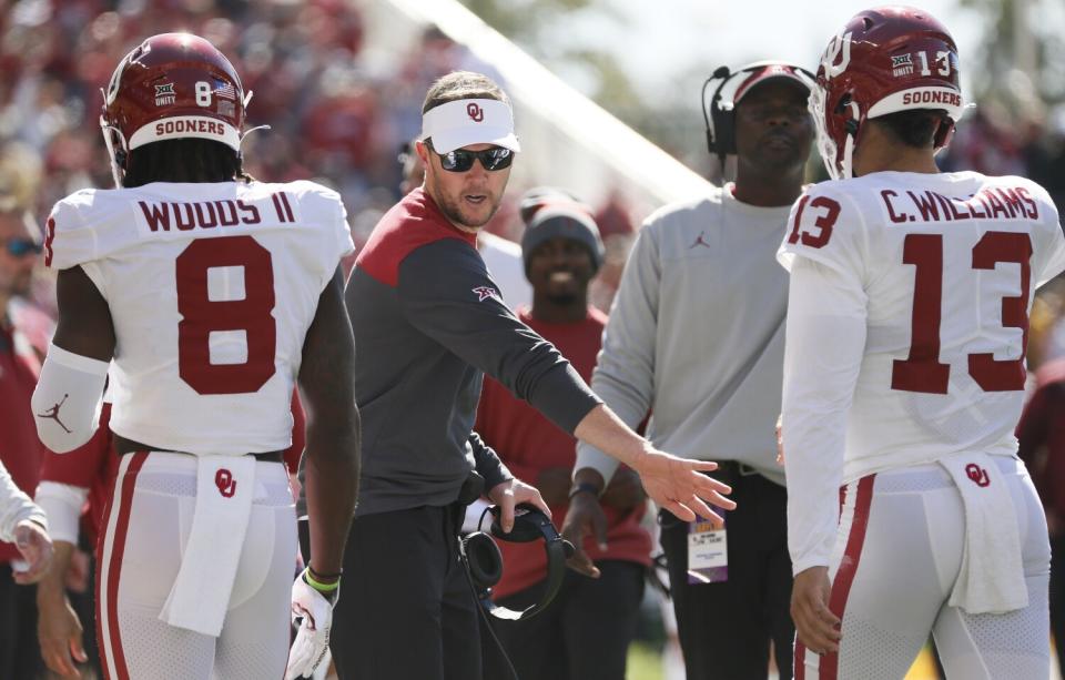 Oklahoma coach Lincoln Riley, center, greets receiver Michael Woods II (8) and quarterback Caleb Williams (13)