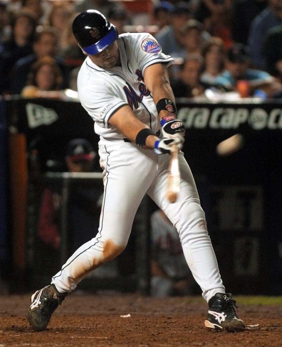 FLUSHING, UNITED STATES:  New York Mets catcher Mike Piazza hits a two-run home run in the bottom of the eighth inning against the Atlanta Braves 21 September 2001 at Shea Stadium in New York City. Security was high and the signs of patriotism everywhere as the two teams played the first baseball game in NY since the terrorist attack on the World Trade Center towers 11 September 2001, which destroyed the buildings. AFP PHOTO/Matt CAMPBELL (Photo credit should read MATT CAMPBELL/AFP/Getty Images)