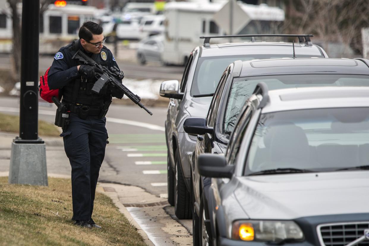 A police officer checks cars in the area after a gunman opened fire at King Sooper grocery store on March 22, 2021, in Boulder, Colorado. Ten people, including a police officer, were killed in the attack.