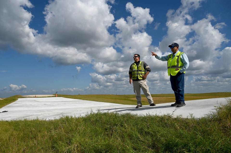 Site operators at Piney Point recently announced a milestone achievement with the closure of the Old Gypsum Stack-South compartment, one of four ponds that need to be closed at the former phosphate processing plant. The white pad to the left of Jeffrey Barath and Herb Donica is a weir, a ramp that prevents water from remaining in the pond. In the event of heavy rain, the pond is designed to overflow past the weir and into a stormwater collection area.