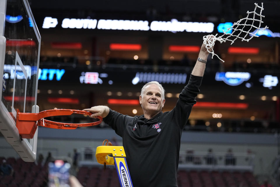 San Diego State head coach Brian Dutcher holds the remains of the net after a Elite 8 college basketball game between Creighton and San Diego State in the South Regional of the NCAA Tournament, Sunday, March 26, 2023, in Louisville, Ky. San Diego State won 57-56. (AP Photo/John Bazemore)