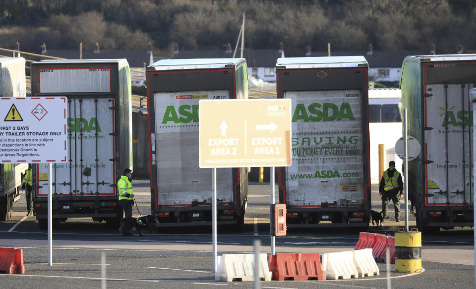 Police conduct a security sweep of lorries at the P&O ferry terminal in the port at Larne on the north coast of Northern Ireland, Friday, Jan. 1, 2021. This New Year's Day is the first day after Britain's Brexit split with the European bloc's vast single market for people, goods and services, and the split is predicted to impact the Northern Ireland border. (AP Photo/Peter Morrison)