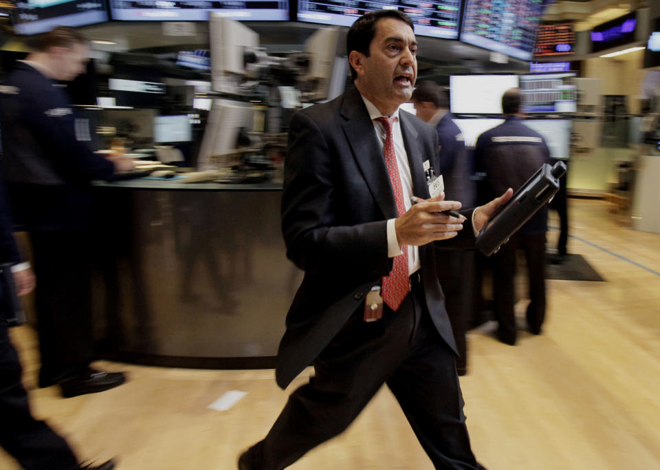 FILE - In this June 1, 2012, file photo, Trader Mark Muller scurries across the floor of the New York Stock Exchange. The global economy’s foundations are weakening, one by one. Already hobbled by Europe’s debt crisis, the world now risks being hurt by slowdowns in its economic powerhouses. With fears of another global economic downturn, investors are sending their money to higher ground _ government bonds in the U.S. and Germany. (AP Photo/Richard Drew, File)