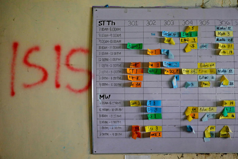 A class schedule is seen on a wall spray-painted with "ISIS" at a school in the most affected war-torn area of Marawi City, Lanao del Sur province, Philippines. (Photo: Eloisa Lopez/Reuters)