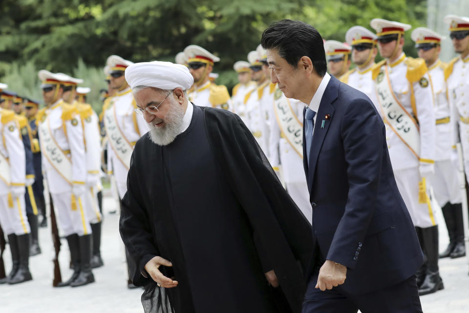 Japanese Prime Minister Shinzo Abe, right, reviews an honor guard as he is welcomed by Iranian President Hassan Rouhani, in an official arrival ceremony at the Saadabad Palace in Tehran, Iran, Wednesday, June 12, 2019. The Japanese leader is in Tehran on an mission to calm tensions between the U.S. and Iran. (AP Photo/Ebrahim Noroozi)