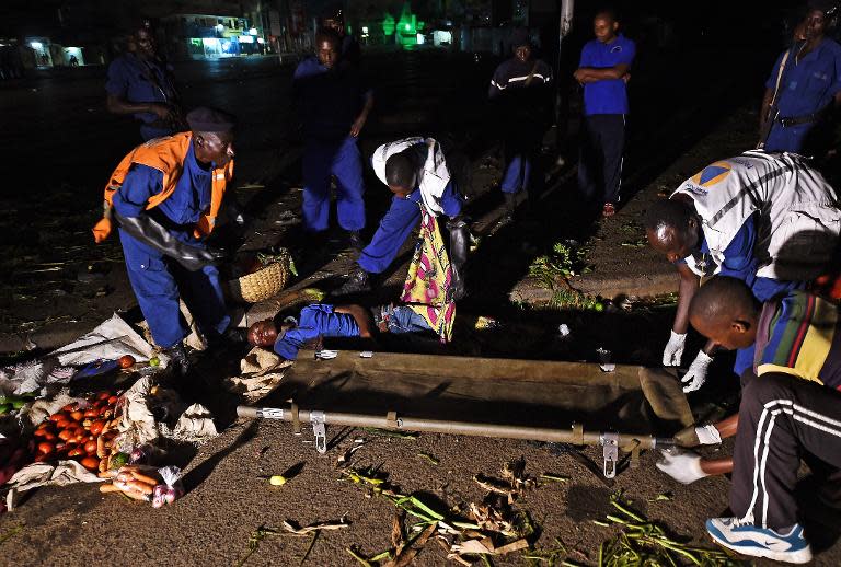 The body of a young man is loaded onto a stretcher by police and medics in the centre of Burundi's capital Bujumbura on May 22, 2015 after a double grenade attack by unknown assailants