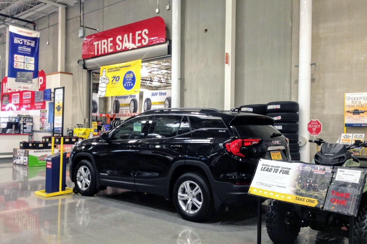 New black SUV car for sale inside Costco, located near the tires section of the store