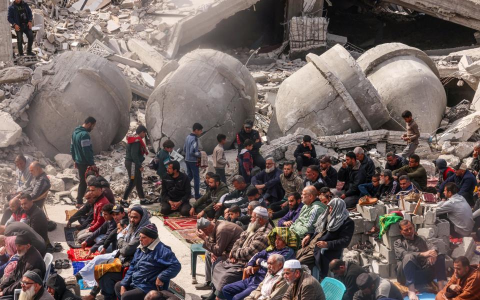 Palestinians attend Friday prayers in front of the ruins of the al-Faruq mosque