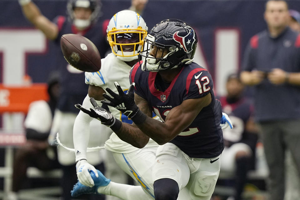 Houston Texans wide receiver Nico Collins (12) pulls in a catch in front of Los Angeles Chargers cornerback J.C. Jackson (27) during the second half of an NFL football game Sunday, Oct. 2, 2022, in Houston. (AP Photo/David J. Phillip)