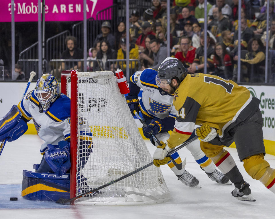 Vegas Golden Knights defenseman Nicolas Hague (14) attempts to wraps a shot around the post on St. Louis Blues goaltender Jordan Binnington (50) during the second period of an NHL hockey game Friday, Dec. 23, 2022, in Las Vegas. (AP Photo/L.E. Baskow)