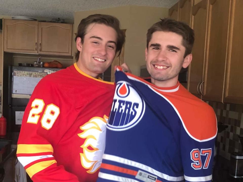 Douglas Henri, left, and his younger brother, Mark Henri, are trying to coexist in the same home despite having different allegiances in the Battle of Alberta. (Colleen Underwood/CBC - image credit)