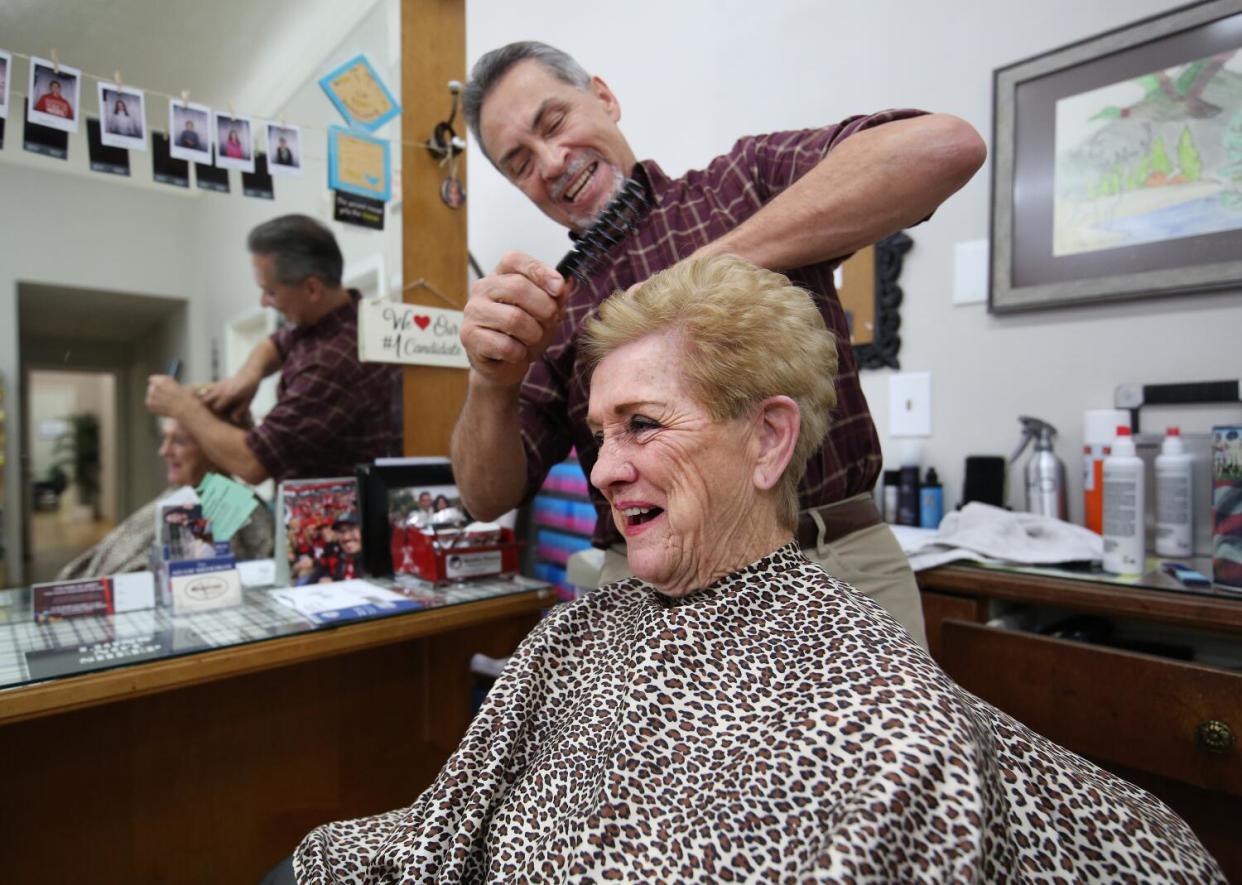 Adam Madeiros works on the hair of Kathy Drew