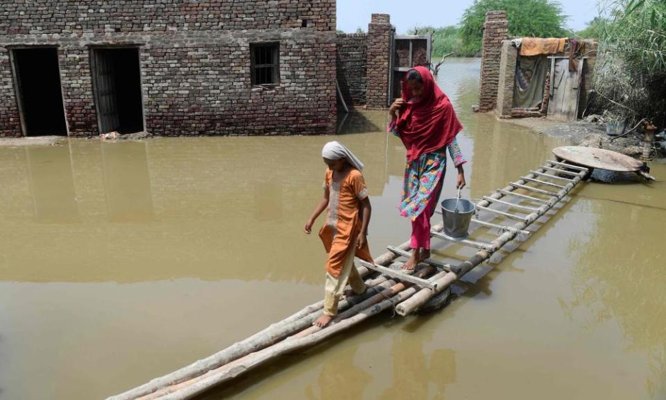 People use a temporary bamboo path near their home in Sindh province, Pakistan. Recent floods ravaged a third of the country and killed 1,500 people.