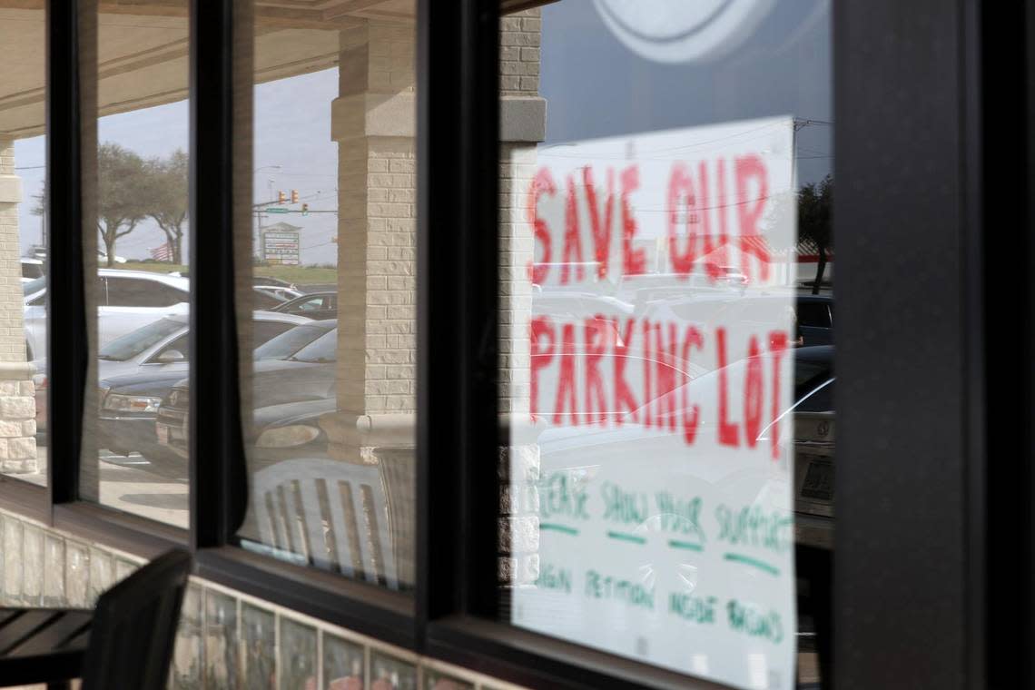 Parked cars are reflected in the window of Bacon’s Bistro and Cafe in Hurst. The restaurant’s parking spaces have been split in half as a new Scooter’s Coffee is built in the lot.