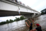 A Honduran migrant, part of a caravan trying to reach the U.S., jumps from the bridge that connects Mexico and Guatemala to avoid the border checkpoint in Ciudad Hidalgo, Mexico, October 19, 2018. REUTERS/Edgard Garrido