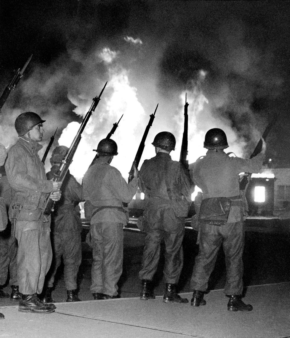 National Guardsmen stand in relief as flames from the Reserve Officer Training Corps (ROTC) building at Kent State University rise into the night sky on May 2, 1970. The guard arrived on campus earlier that evening after the mayor of Kent, LeRoy Satrom, declared a state of emergency.