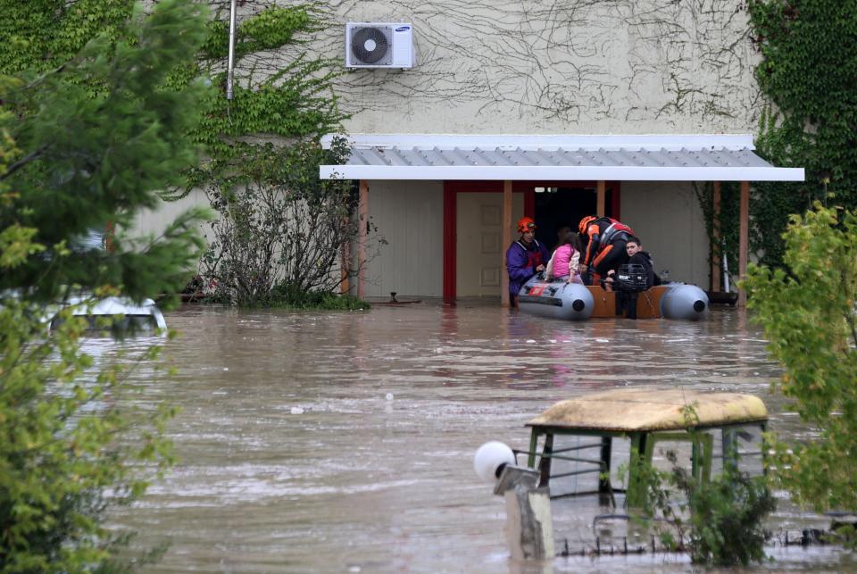 Firefighters with a rubber dinghy evacuee people from a flooded building in Larissa, central Greece, Wednesday, Sept. 6, 2023. Fierce rainstorms are battering neighboring Greece, Turkey and Bulgaria, causing several deaths. (AP Photo/Vaggelis Kousioras)