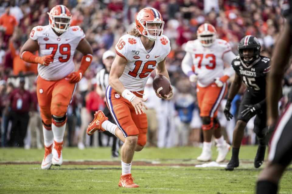 Clemson quarterback Trevor Lawrence (16) carries the ball against South Carolina during the first half of an NCAA college football game Saturday, Nov. 30, 2019, in Columbia, S.C. (AP Photo/Sean Rayford)