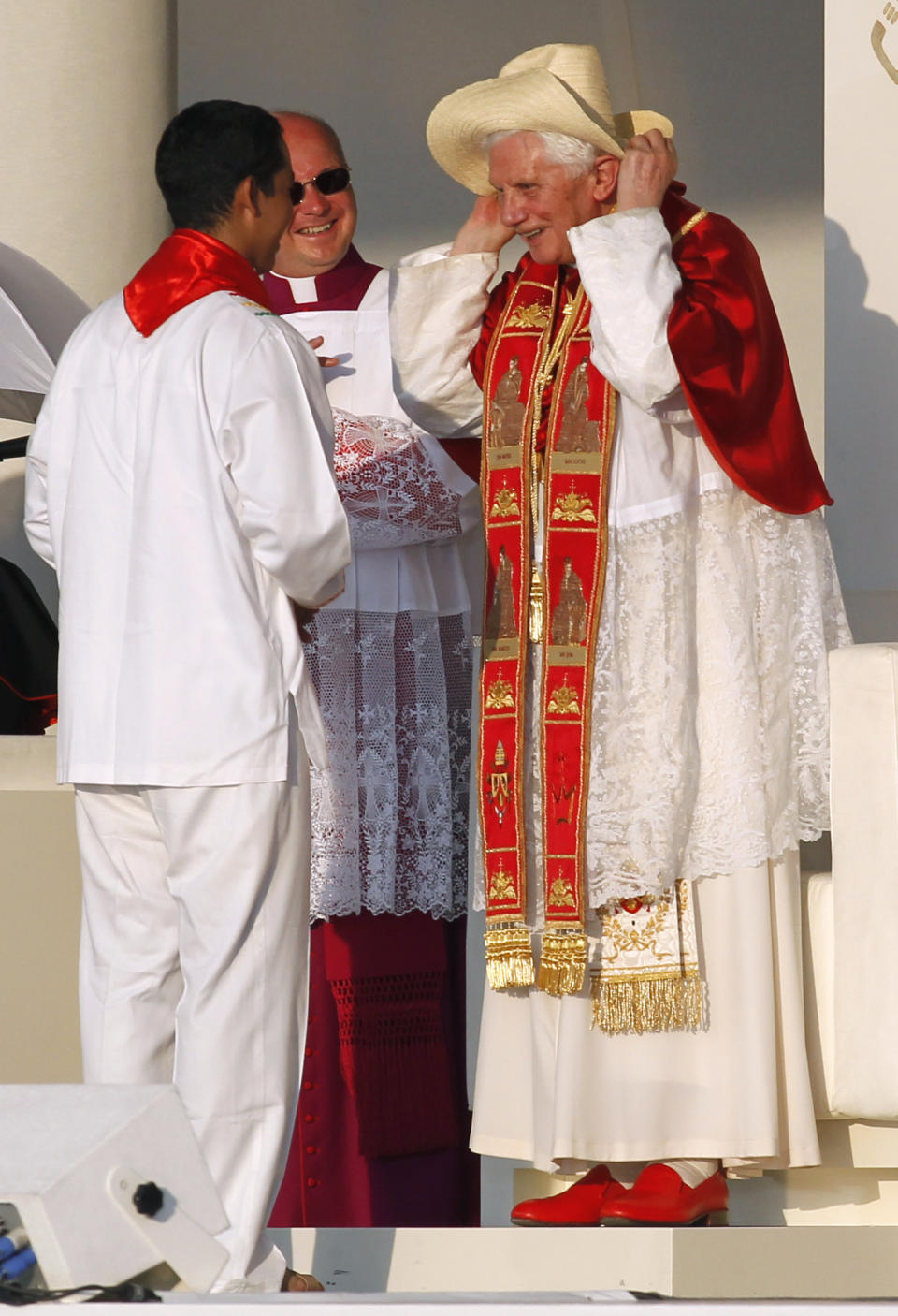 FILE - Pope Benedict XVI puts on a hat presented to him by a young man representing the youth from Latin America in Madrid's Cibeles square on Aug. 18, 2011. Pope Emeritus Benedict XVI, the German theologian who will be remembered as the first pope in 600 years to resign, has died, the Vatican announced Saturday. He was 95. (AP Photo/Armando Franca, File)