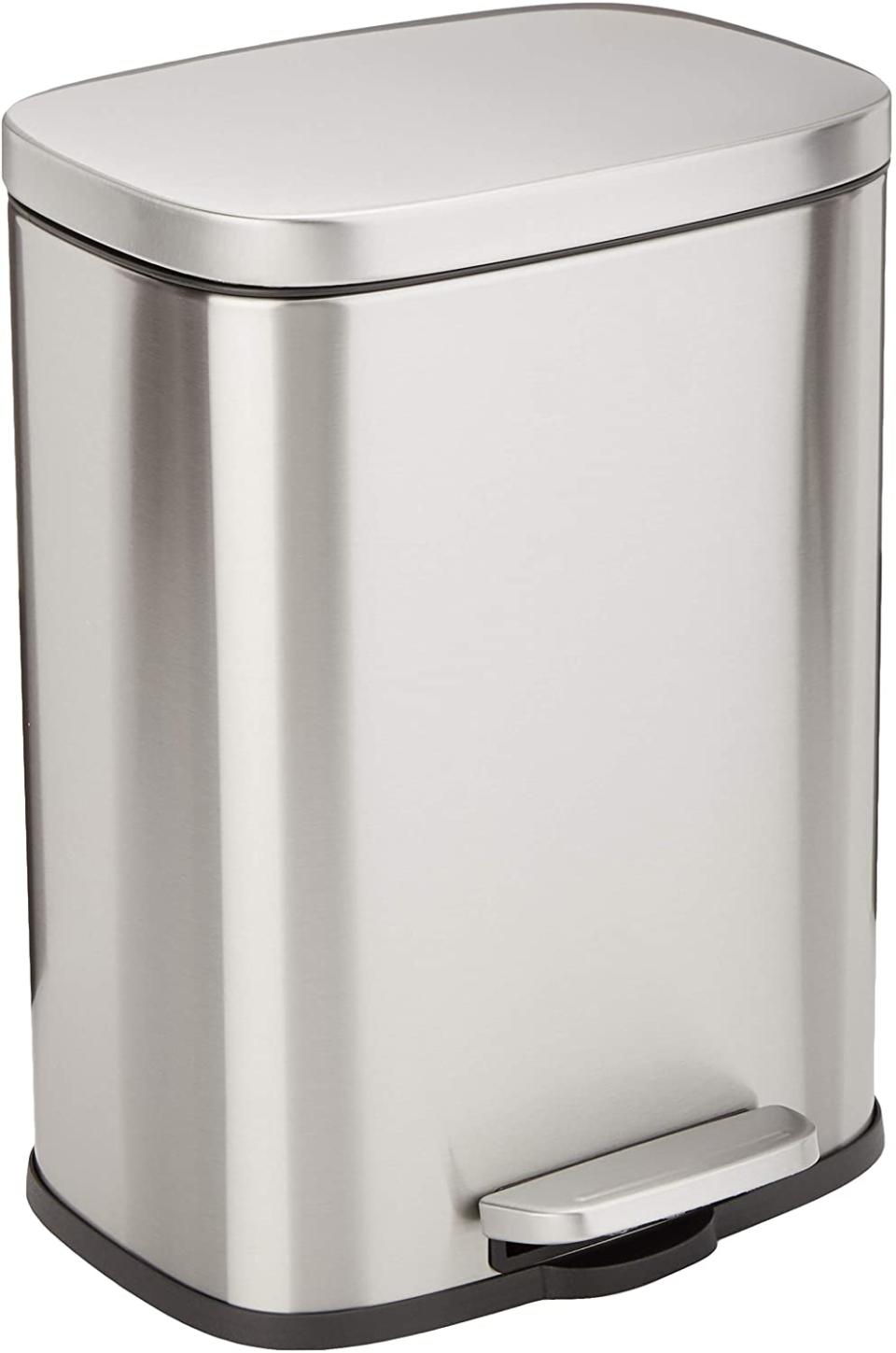 A tall silver pedal bin with black trim on a white background.