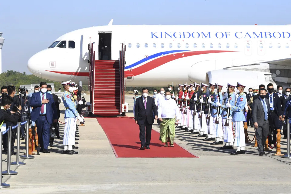 In this photo provided by An Khoun Sam Aun/National Television of Cambodia, Cambodian Prime Minister Hun Sen, center left, reviews an honor guard with Myanmar Foreign Minister Wunna Maung Lwin, center right, on his arrival at Naypyitaw International Airport in Naypyitaw, Myanmar, Friday, Jan 7, 2022. (An Khoun Sam Aun/National Television of Cambodia via AP)