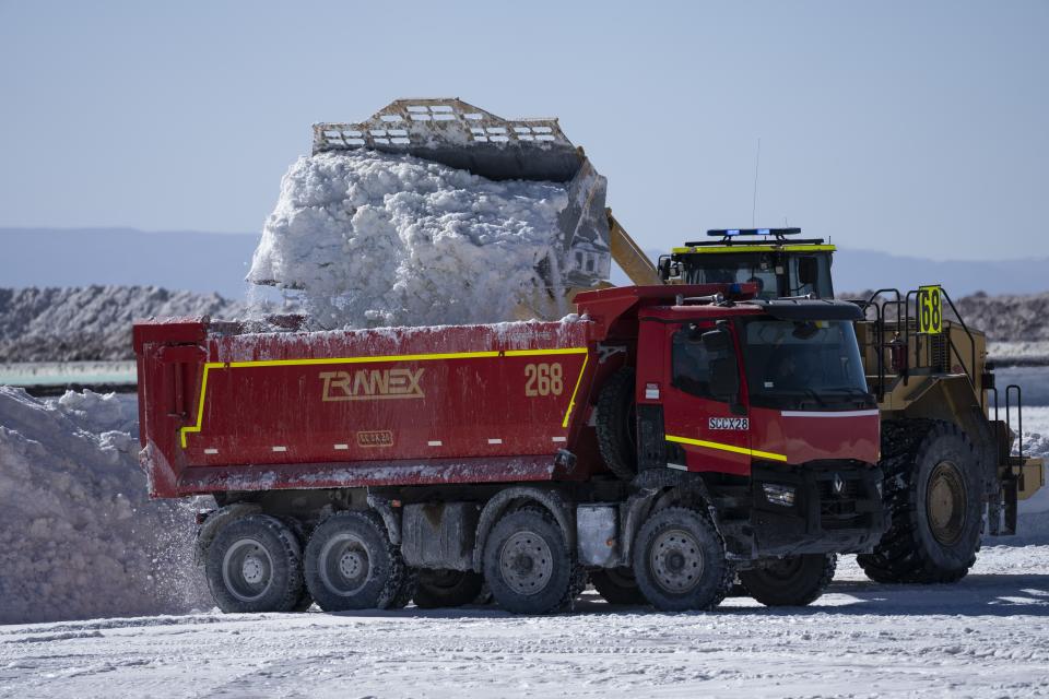 An excavator dumps salt used as part of lithium processing, into a truck at the Albemarle lithium mine in Chile's Atacama desert, Monday, April 17, 2023. (AP Photo/Rodrigo Abd)